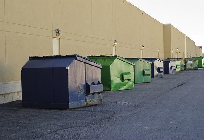 a group of construction workers taking a break near a dumpster in Bertram